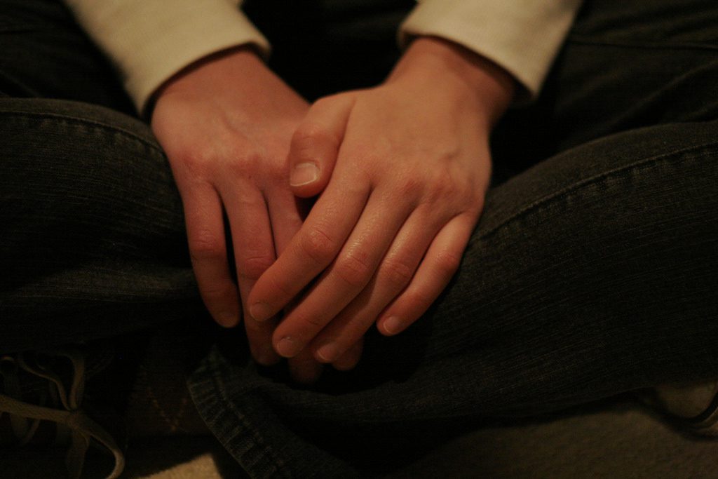 Hands folded on lap