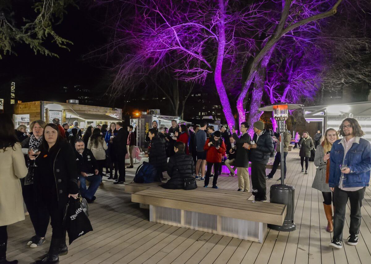 pop-up village opening ceremony at night with people milling about