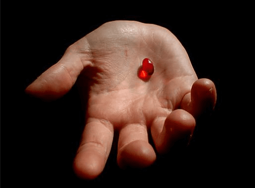 hand holding a red pill