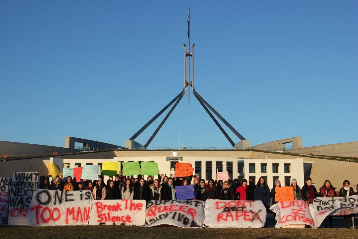 Protesters outside Parliament House on Friday morning, holding mattreses with messages against sexual assault on campus.