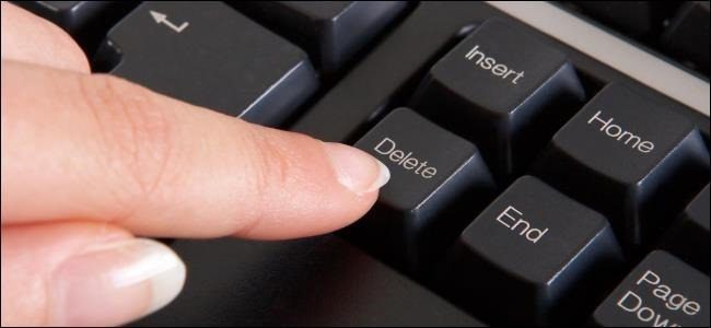 finger pressing the delete key on a computer