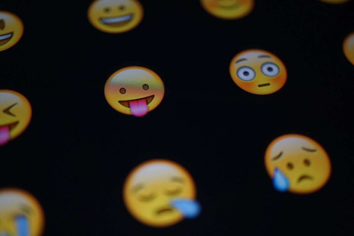 Several emoticons on a black background. Emoticons are yellow. Some have their tongue sticking out, some are crying.