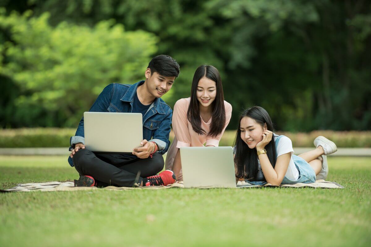 Chinese students sitting on grass