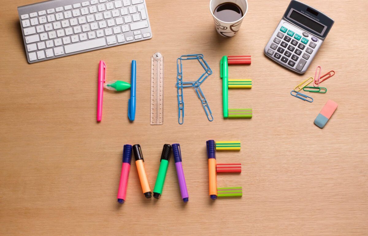 the words 'hire me' spelt out in stationary