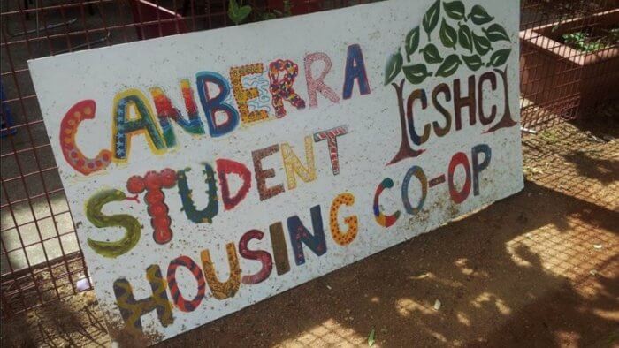 A hand-painted sign in multi-coloured lettering that says Canberra Student Housing Co-Op.