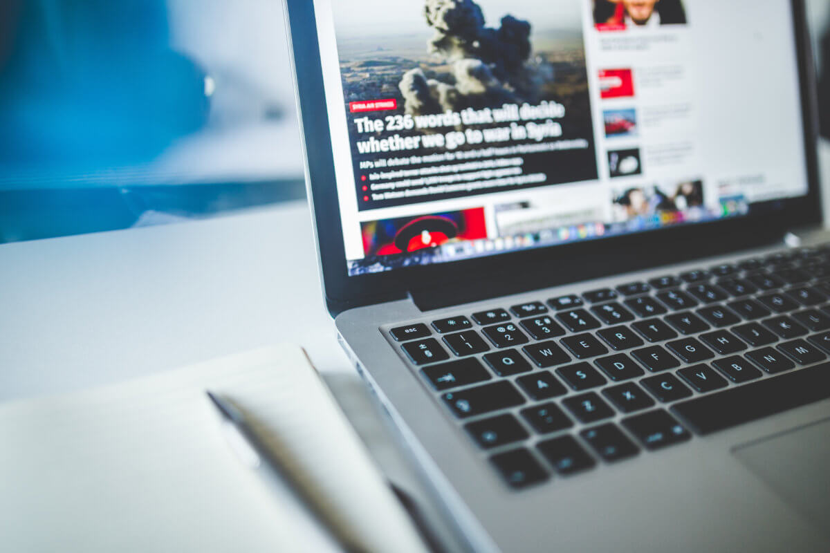 A laptop screen open to a news site. An image of a fighter is visible on the screen.