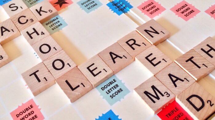 A photo of a scrabble board, with tiles linking up to show "school", "to", and "learn"