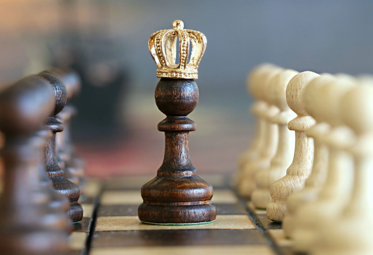 A chessboard with the queen at the centre, being surrounded by pawns on both sides.