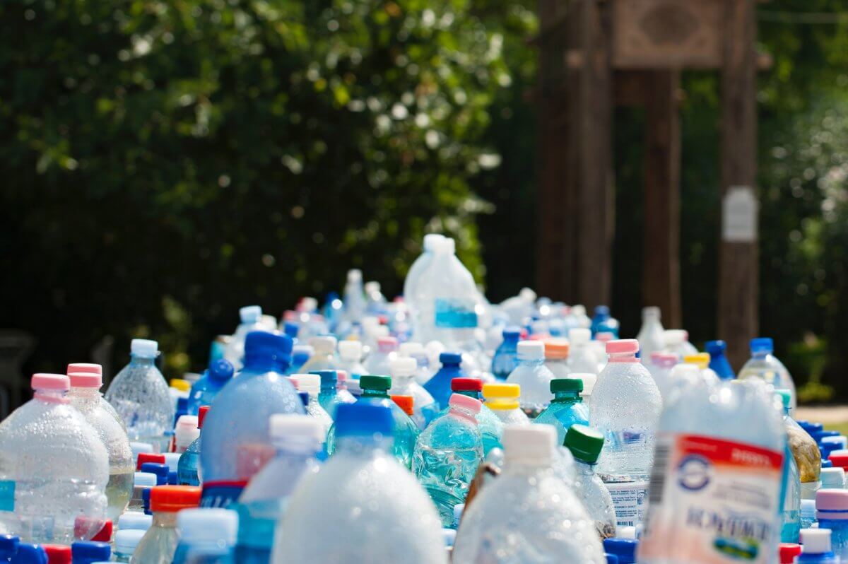 A pile of tens of empty plastic bottles, all standing upright