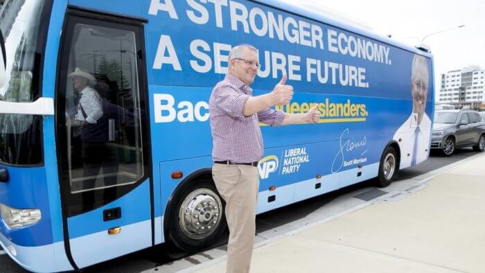 Scott Morrison standing in front of his branded Queensland campaigning bus.